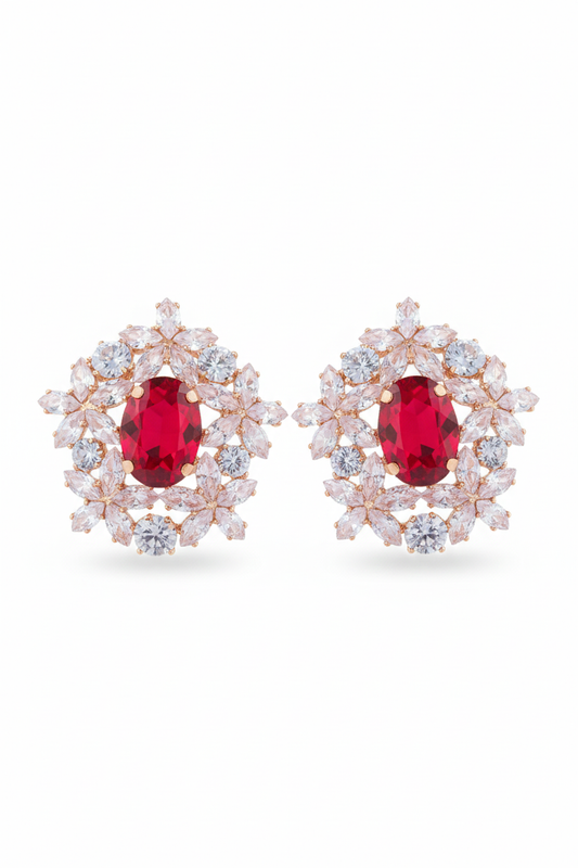 Pair of earrings with red gemstones and diamond-like stones on a white background