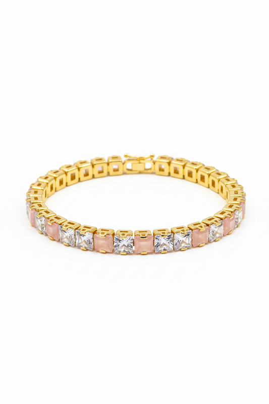 Gold bracelet with pink stones on a white background