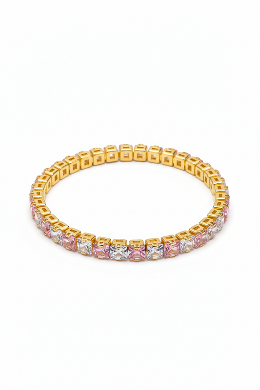 Gold bracelet with pink and clear gemstones on a white background